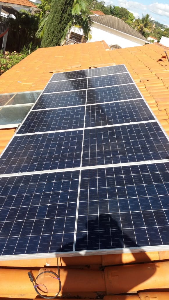 Close de painéis solares no telhado com conector no fio na beira da telha
