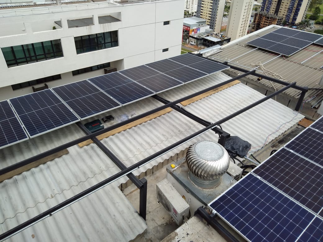 Terraço urbano com painéis solares em estrutura preta e caixa de ferramentas no chão